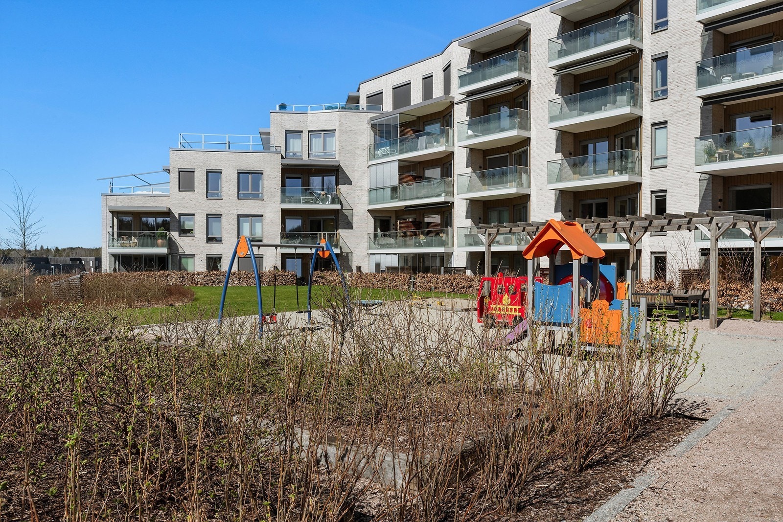 Fellesområdene er pent opparbeidet med blant annet lekeapparater, sittegrupper og gressplen. Galleribilde