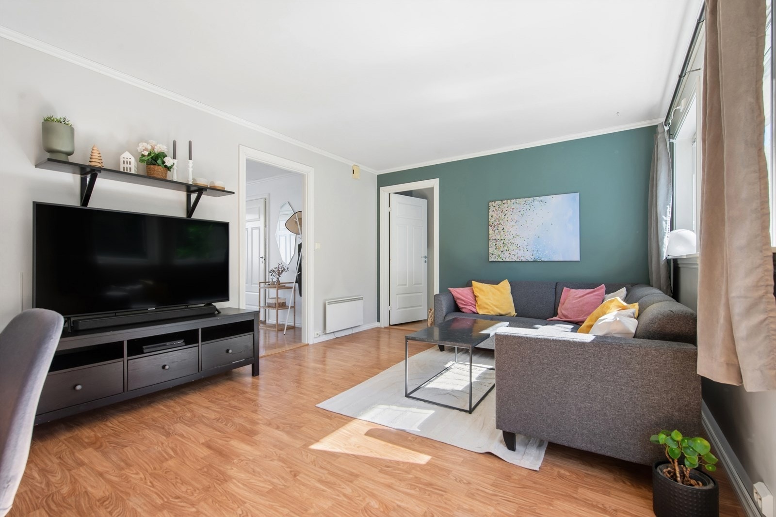 Stuen er lett å møblere og har en naturlig inndeling mellom TV-krok og spiseplass. Galleribilde