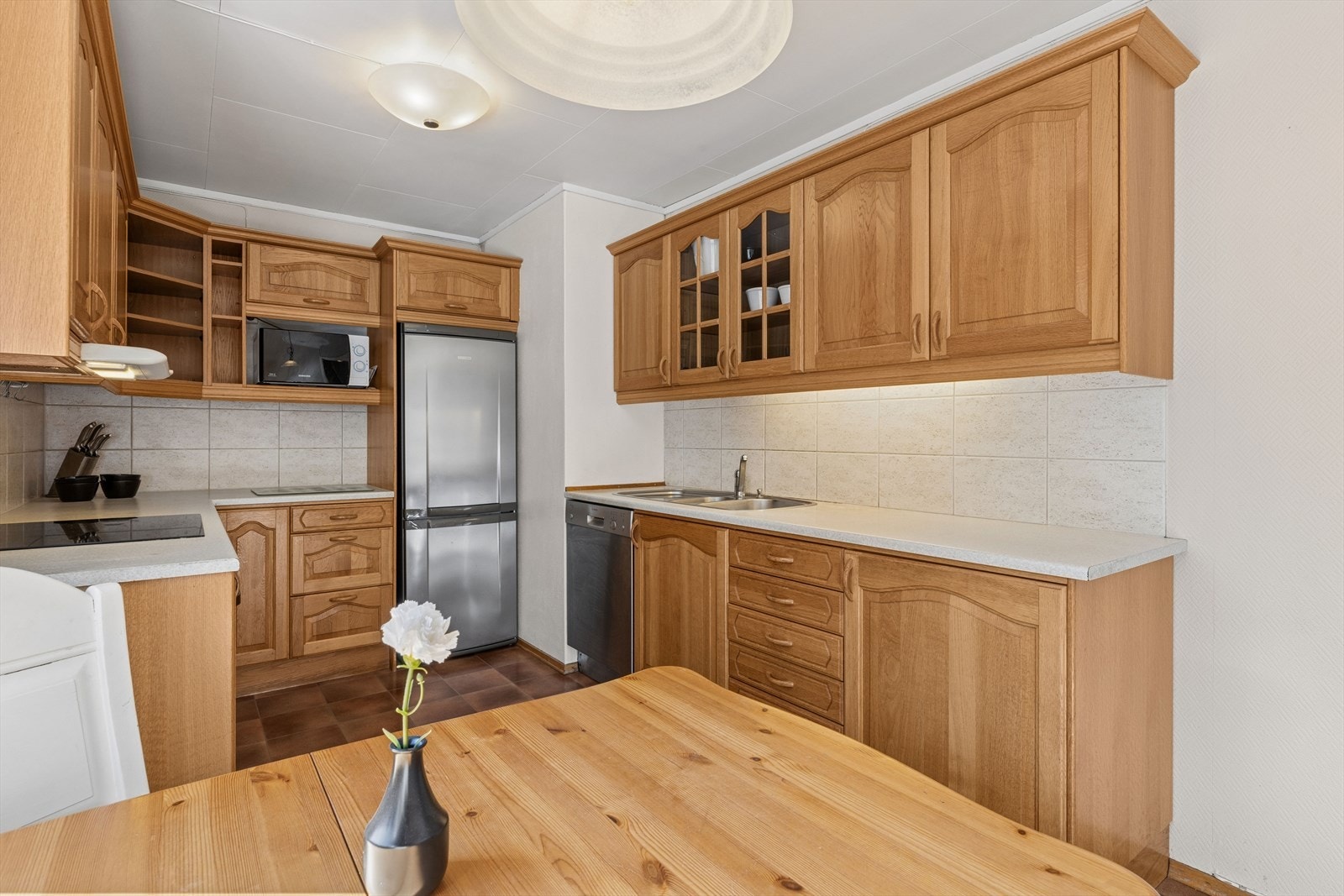 Innredningen har profilerte fronter og laminat benkeplate med fliser over benken. Galleribilde