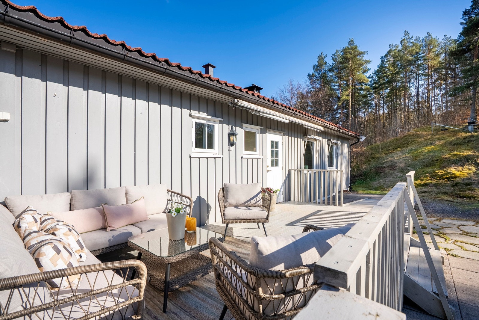 En hyggelig, lun og solrik terrasse ved inngangspartiet som innbyr til gode stunder Galleribilde