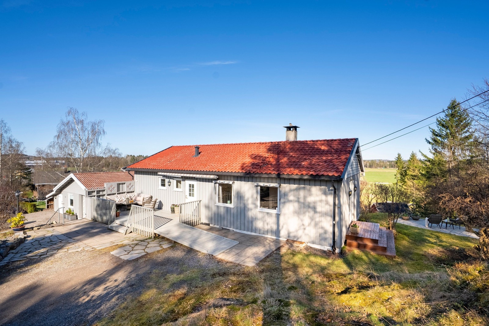 Innholdsrik tomt over flere nivåer med kort vei fra stue til hageområde som gir en naturlig flyt mellom inne og ute Galleribilde