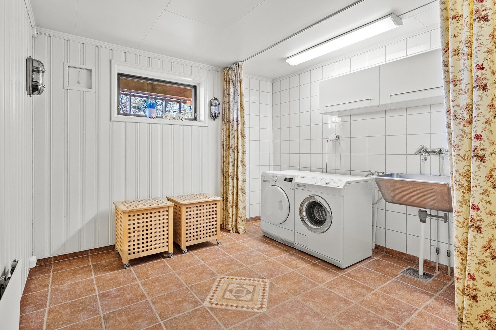 Stort vaskerom med flis på gulv (m/varmekabler), panel på vegger og malte plater i himling. Rommet er innredet med utslagsvask og overskap. Galleribilde