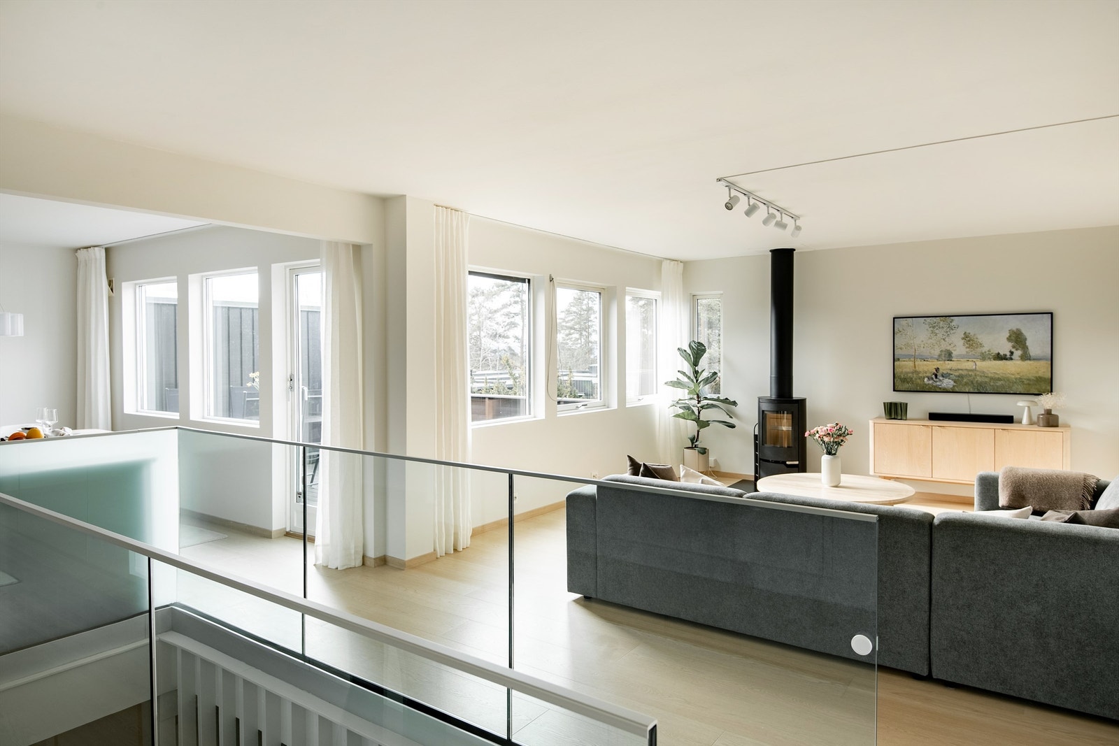 Fra trappen kommer du opp til et lyst og luftig allrom. Glassrekkverket sikrer en åpen romfølelse. Galleribilde