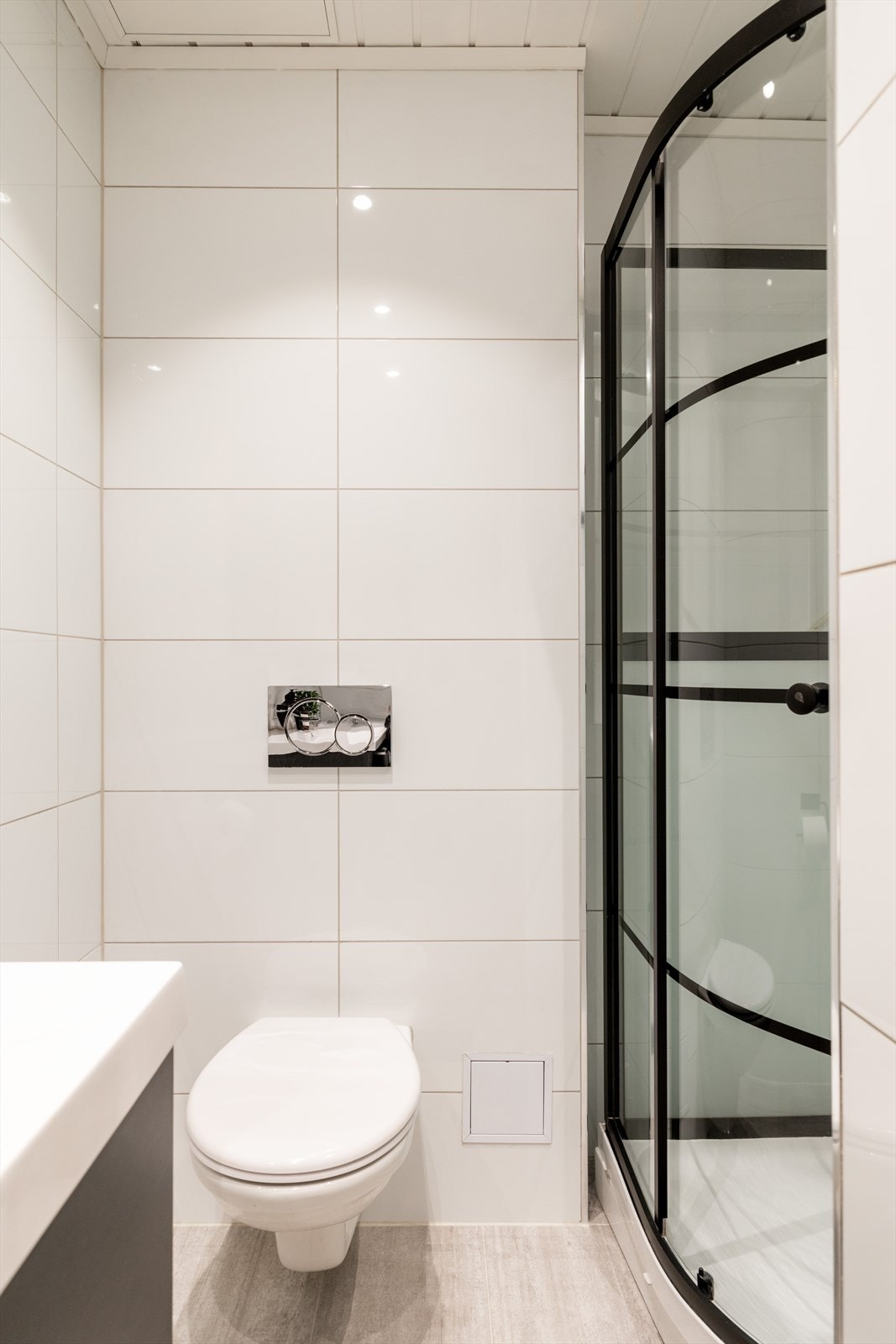 Badet er innredet med vegghengt klosett, servant nedfelt i innredning, speilskap m/lys og dusjkabinett. Videre er det opplegg for vaskemaskin. Galleribilde