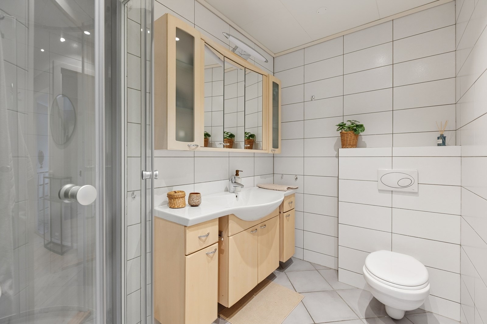 Badet er fra 2006 og er innredet med lyse fliser på gulv og vegger. I gulvet har man også varmekabler for ekstra komfort. Galleribilde