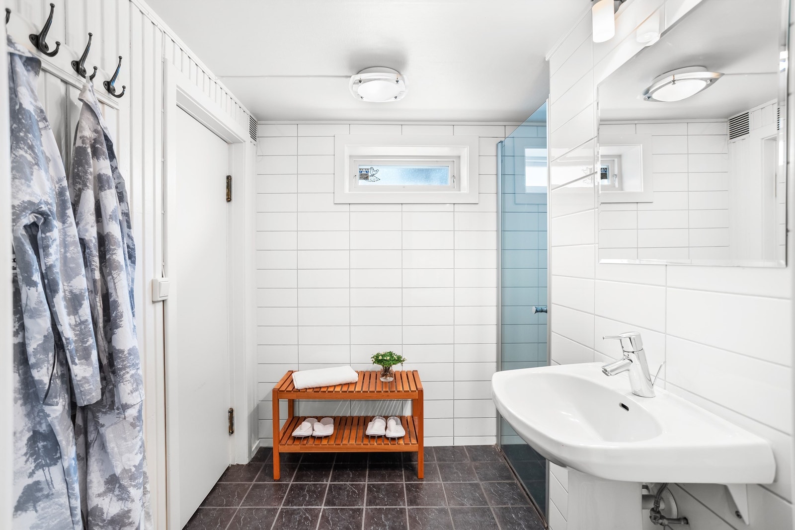 Badet i kjelleren består videre av flislagt gulv med varme, vegghengt servant, speil med overlys og en dusjnisje, i tillegg til inngang til badstuen her. Galleribilde
