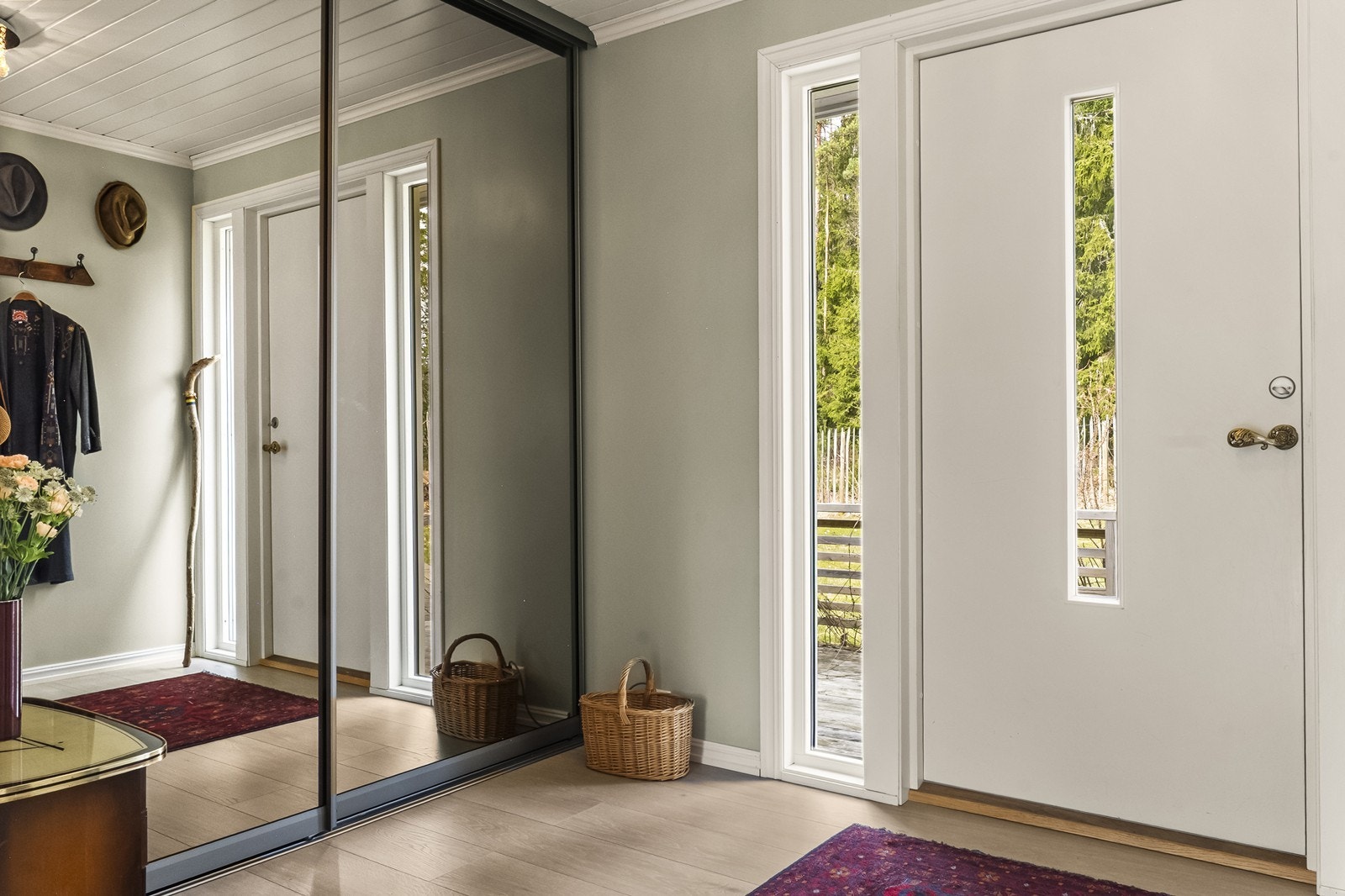 En stor skyvedørsgarderobe med speilfronter gir rikelig med oppbevaringsplass for yttertøy. Galleribilde