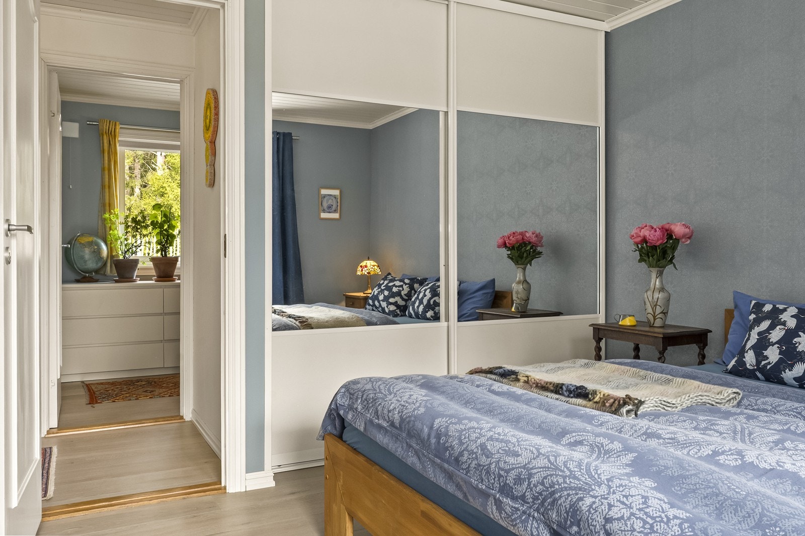 En stor skyvedørsgarderobe med speilfronter gir rikelig med oppbevaringsplass. Galleribilde