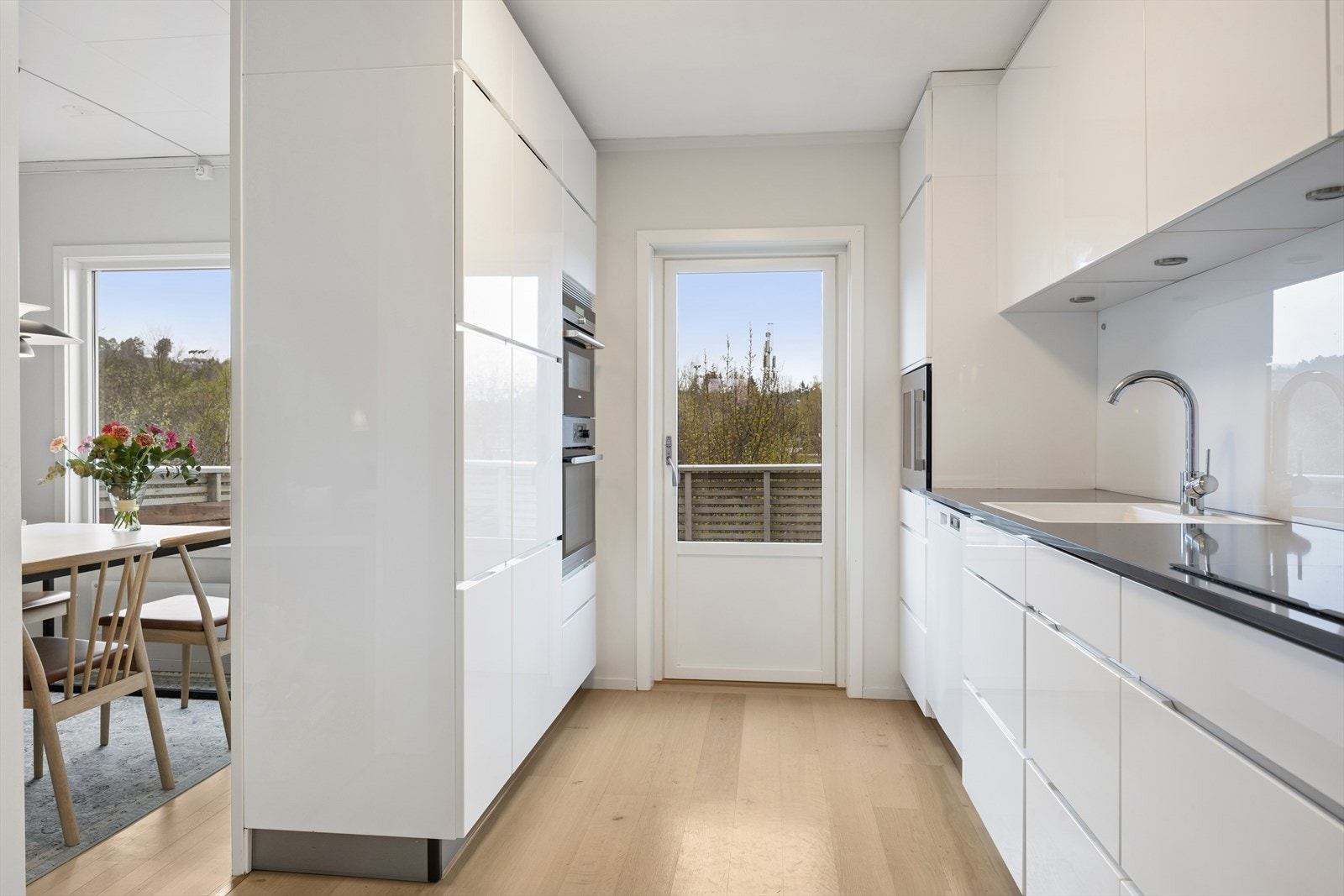 Fra kjøkkenet er det direkte utgang til en vestvendt veranda, som utvider den sosiale sonen på varme dager. Galleribilde