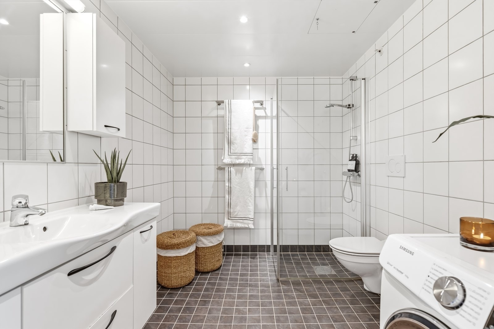 Dette badet er en prefabrikkert modul fra byggeåret 2014, med dusjhjørne, veggmontert toalett og servantinnredning. Galleribilde