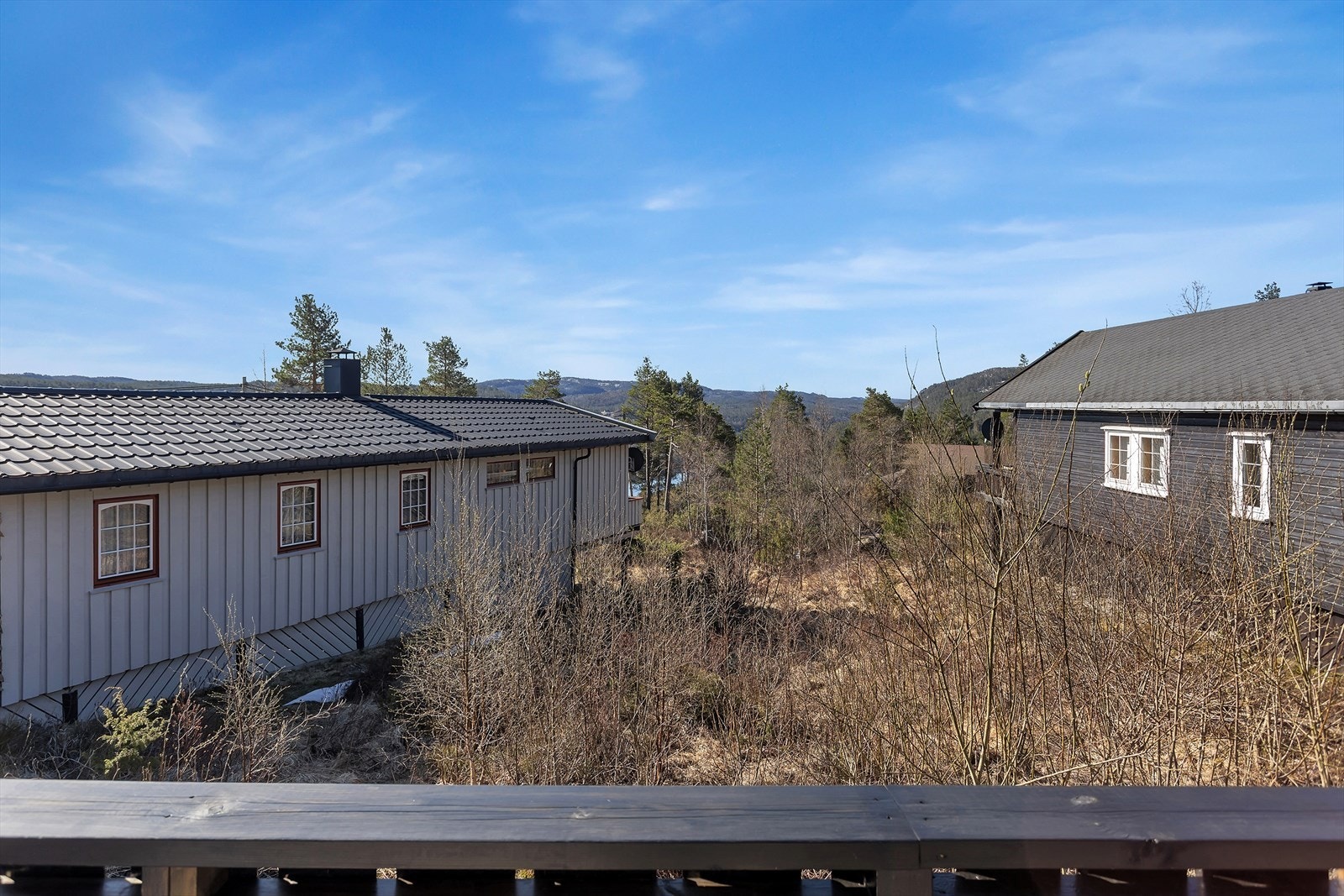 Fra hytta og terrassen har man utsikt over hyttefeltet og det omkringliggende landskapet. Galleribilde