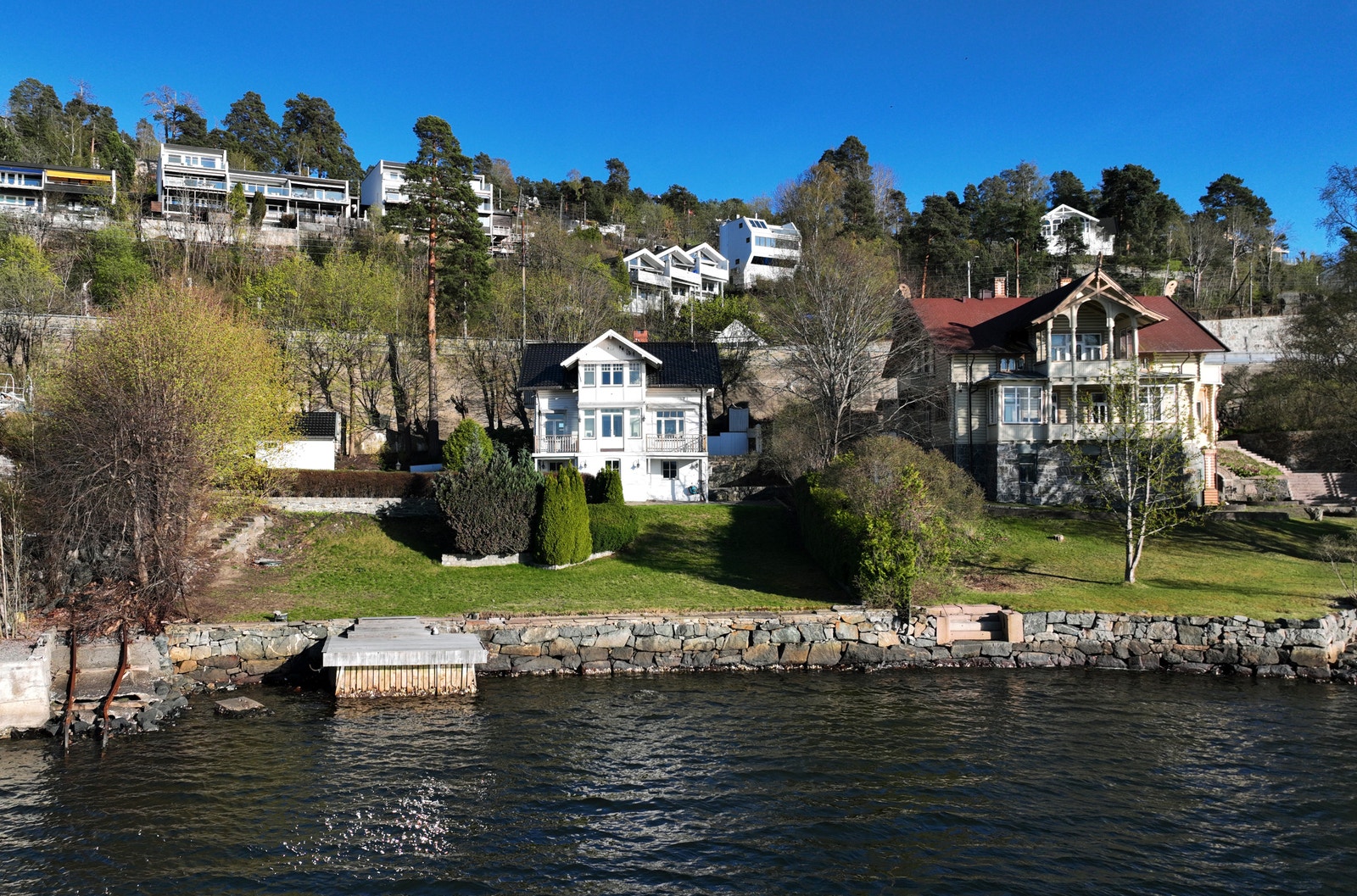 Beliggenheten er tilbaketrukket og rolig, til tross for sentrumsnær plassering. Arealet langs sjøen beholdes i kommunens eie. Foto: Norheim foto Galleribilde