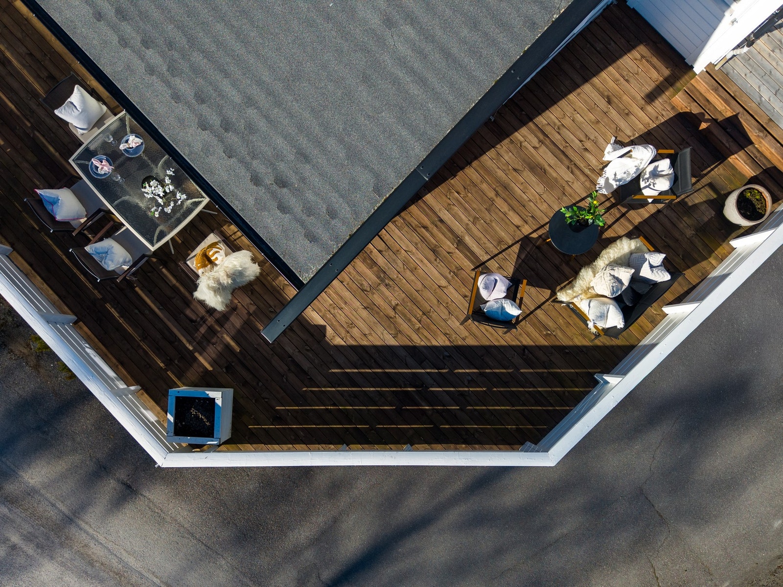 Luftfoto av en romslig terrasse med tregulv og hvit rekkverk, perfekt for utendørs opphold. Galleribilde