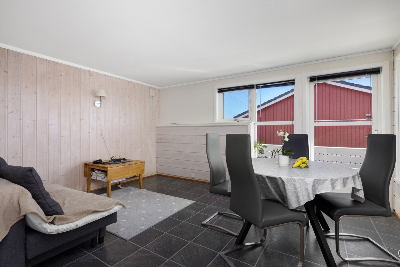 Romslig stue med store vinduer som gir godt lysinnslipp og utsikt mot nabobygning. (hybel) Galleribilde