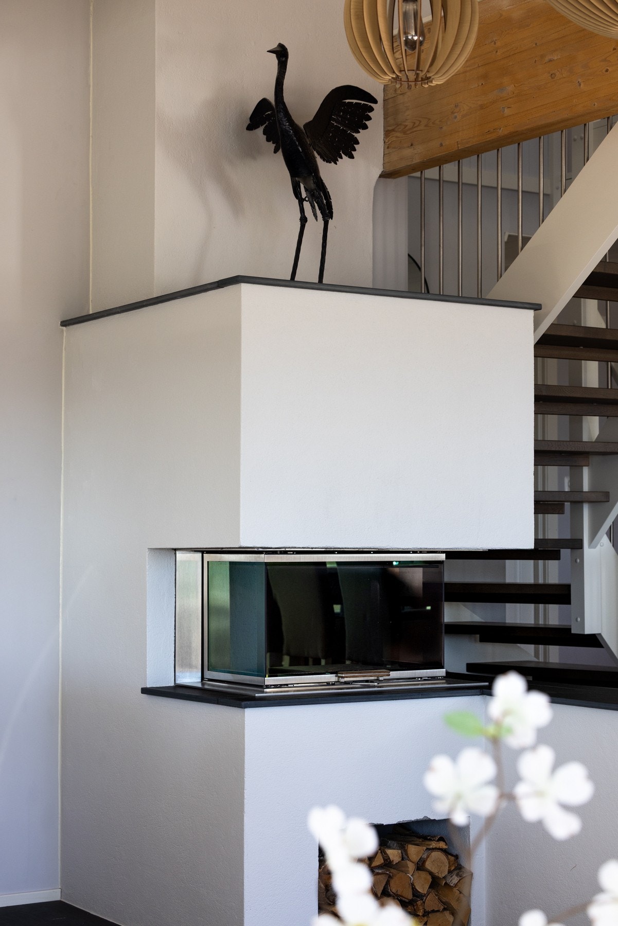 Peis med moderne design og glassdører, plassert ved siden av en trapp med mørke trinn og metallrekkverk. Galleribilde
