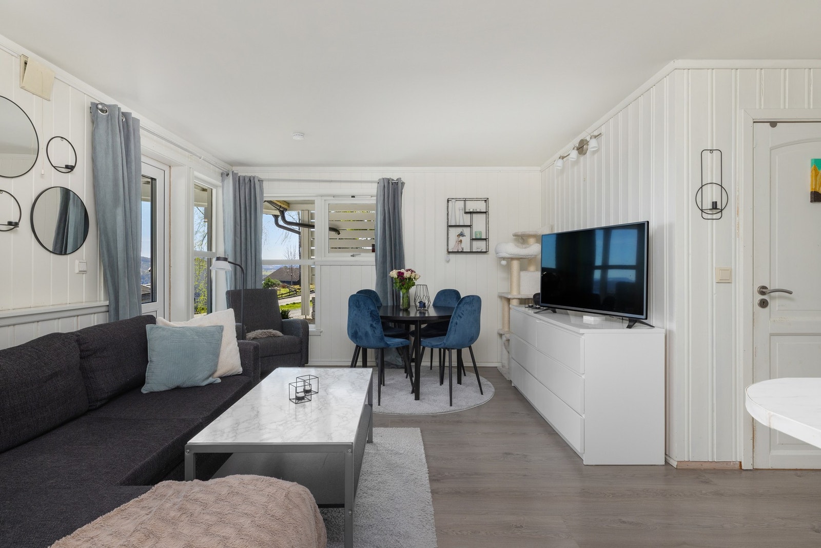 Lys stue med store vinduer, panelvegger og utsikt. (utleie) Galleribilde