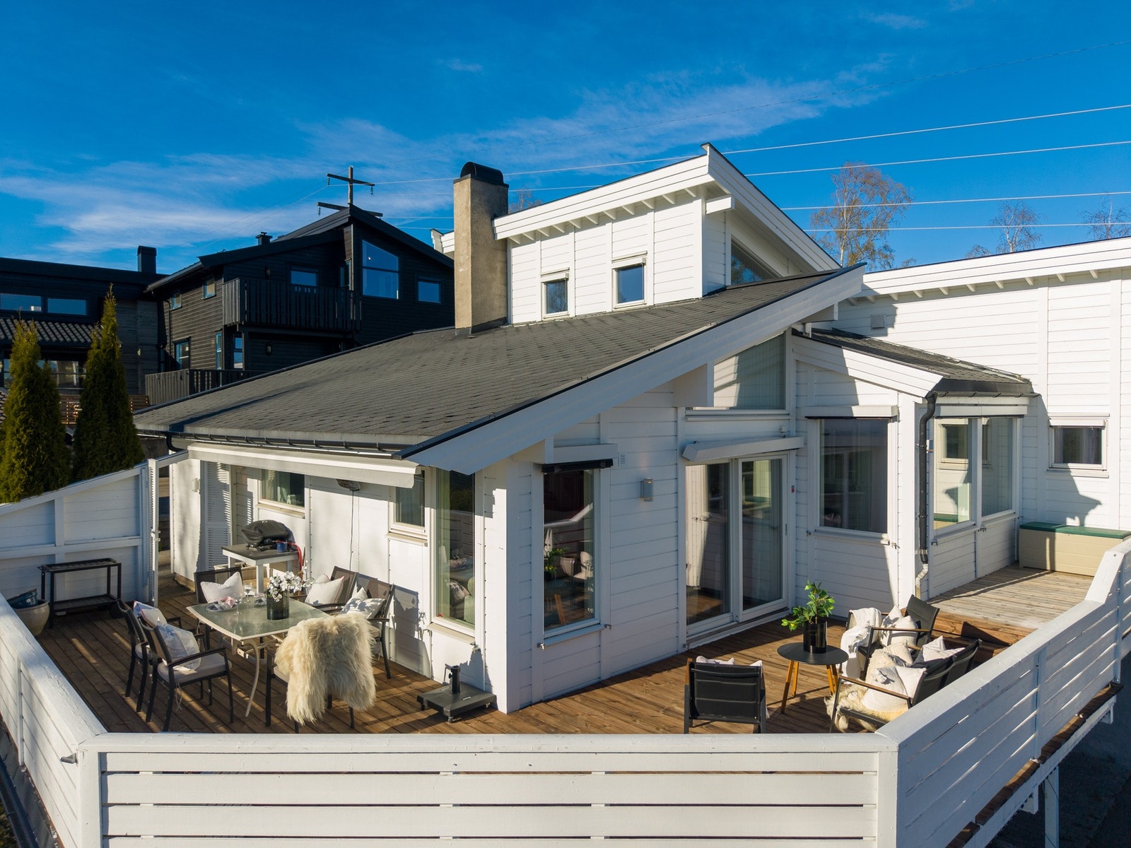 Lys og moderne bolig med stor terrasse og flere sittegrupper. Galleribilde