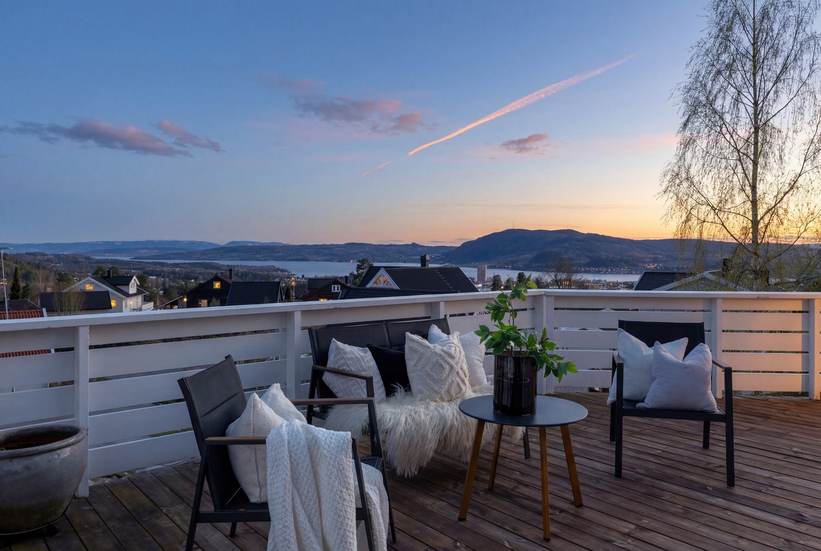 Terrasse med utsikt over nærliggende hus og fjell i horisonten, perfekt for å nyte solnedgangen. Galleribilde