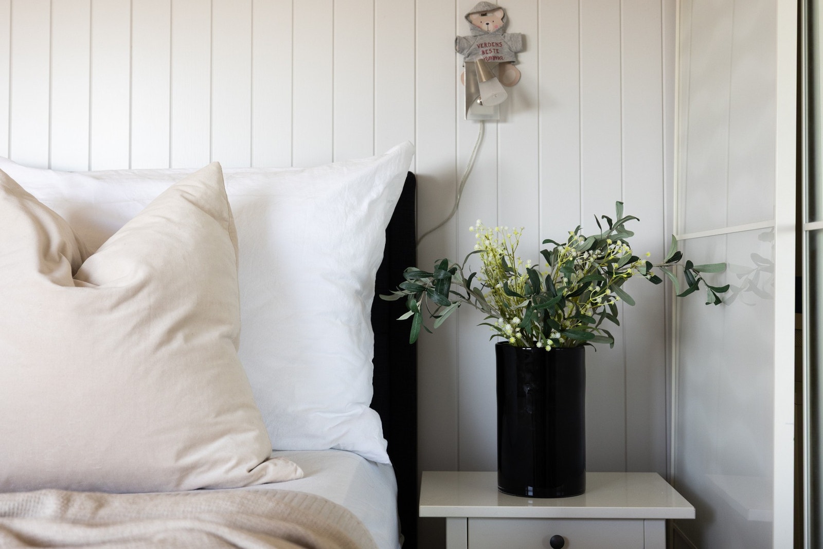 Lyst soverom med panelvegger og nattbord. Galleribilde