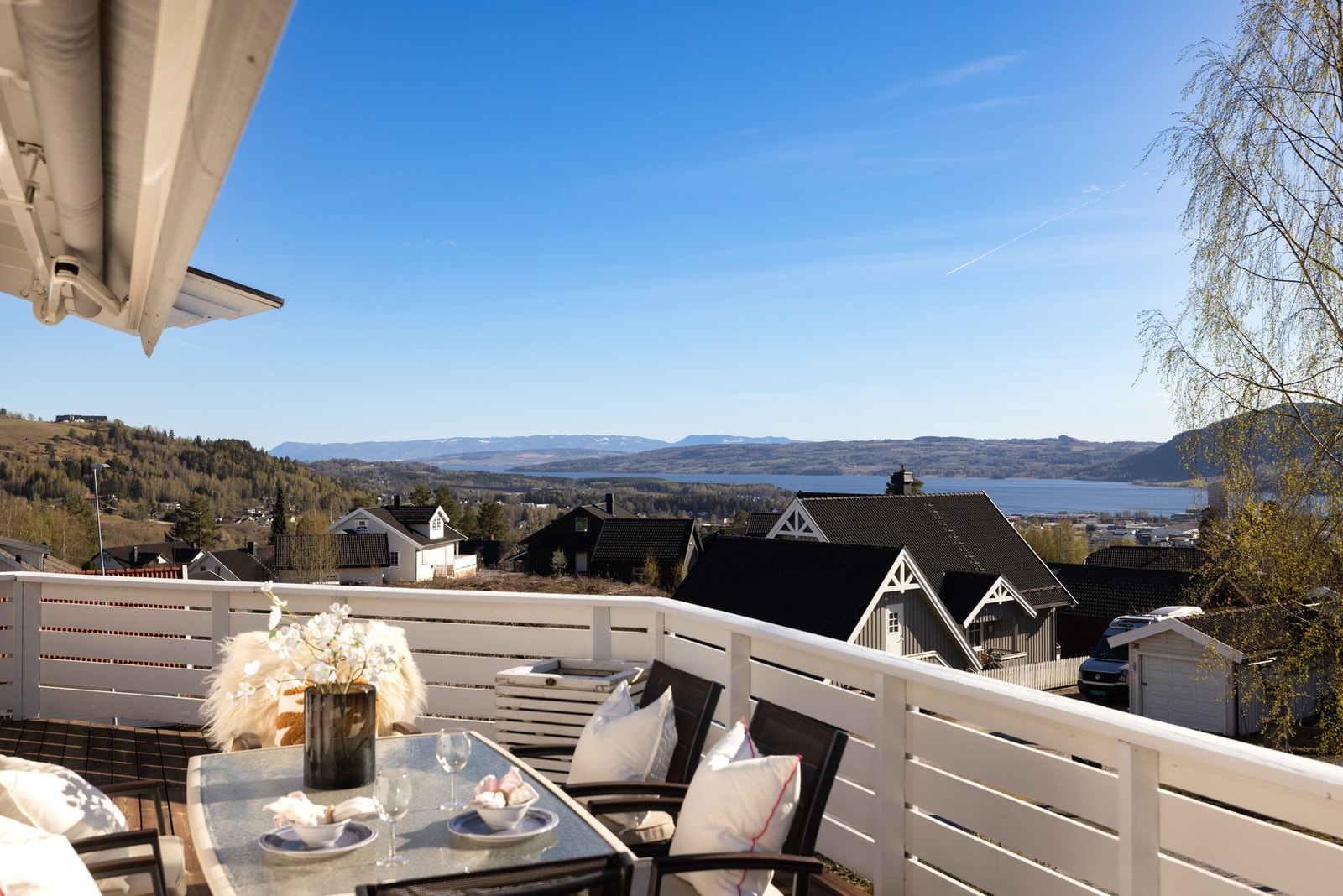 Utsikt over nabolag med fjord og fjell i bakgrunnen, sett fra en terrasse. Galleribilde
