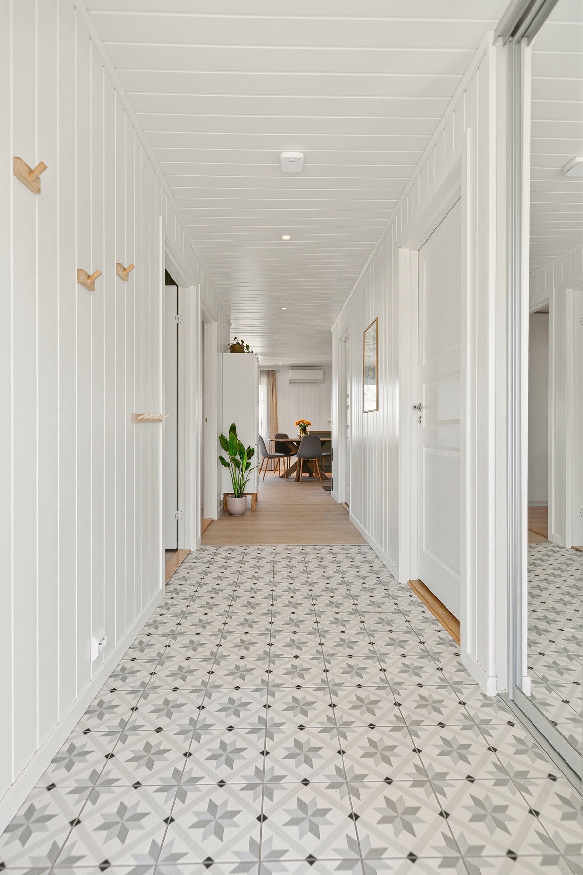 Flislagt entrè med skyvedørsgarderobe. Galleribilde