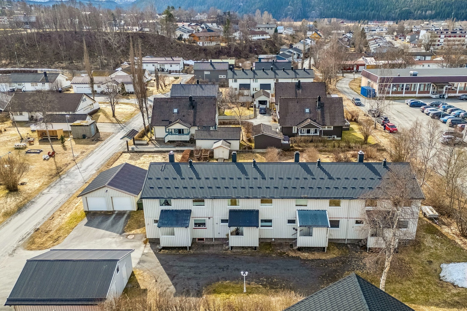 Til venstre i bildet ser du et område som er regulert til grøntareal. Her har beboere i gata ordnet med gapahuk, sandkasse, benker, huske m.m. Galleribilde
