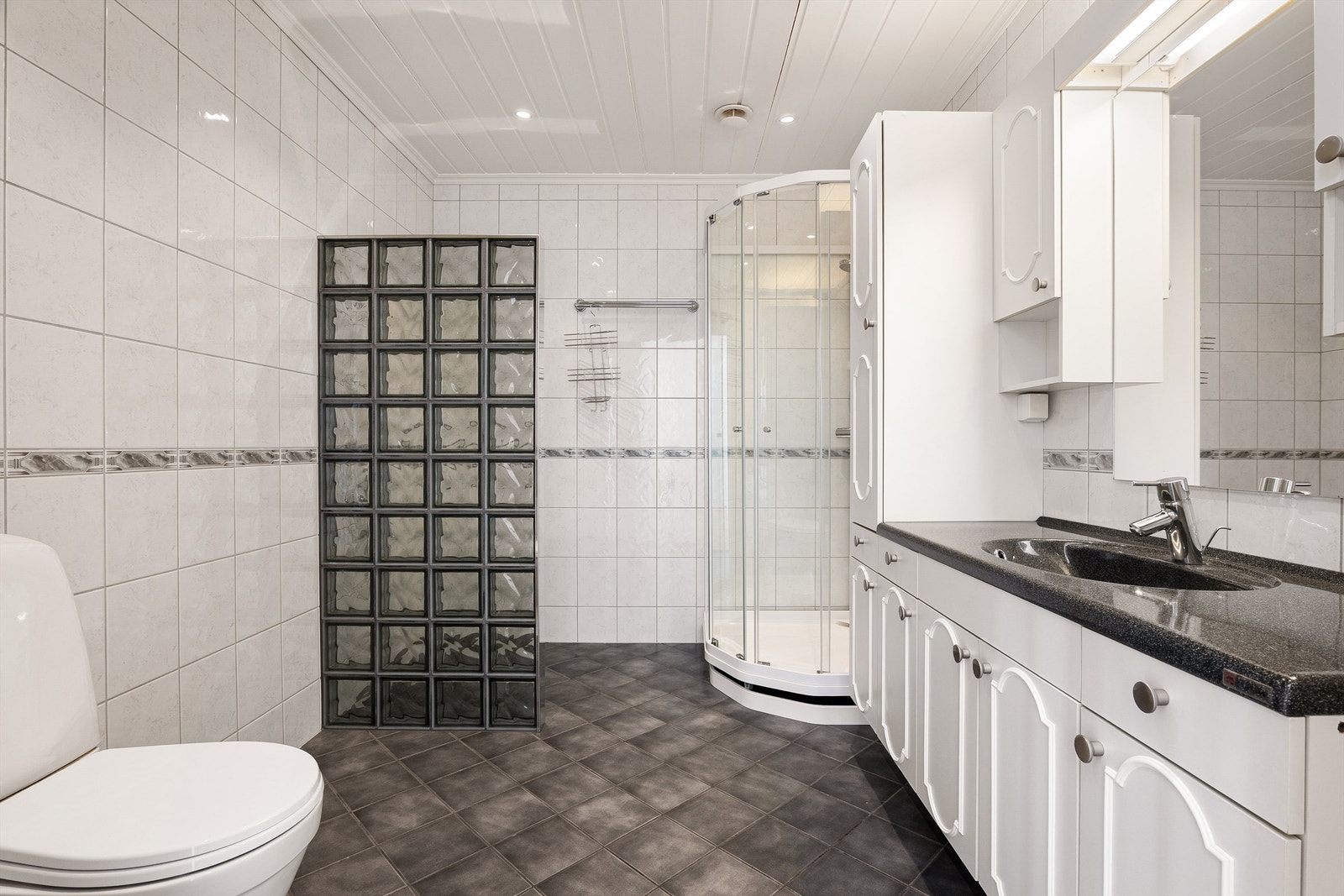 Badet er modernisert siden boligen ble oppført og har i senere tid vært benyttet med dusjkabinett som begrenser vann på flisene. I gulvet er det varme. Galleribilde