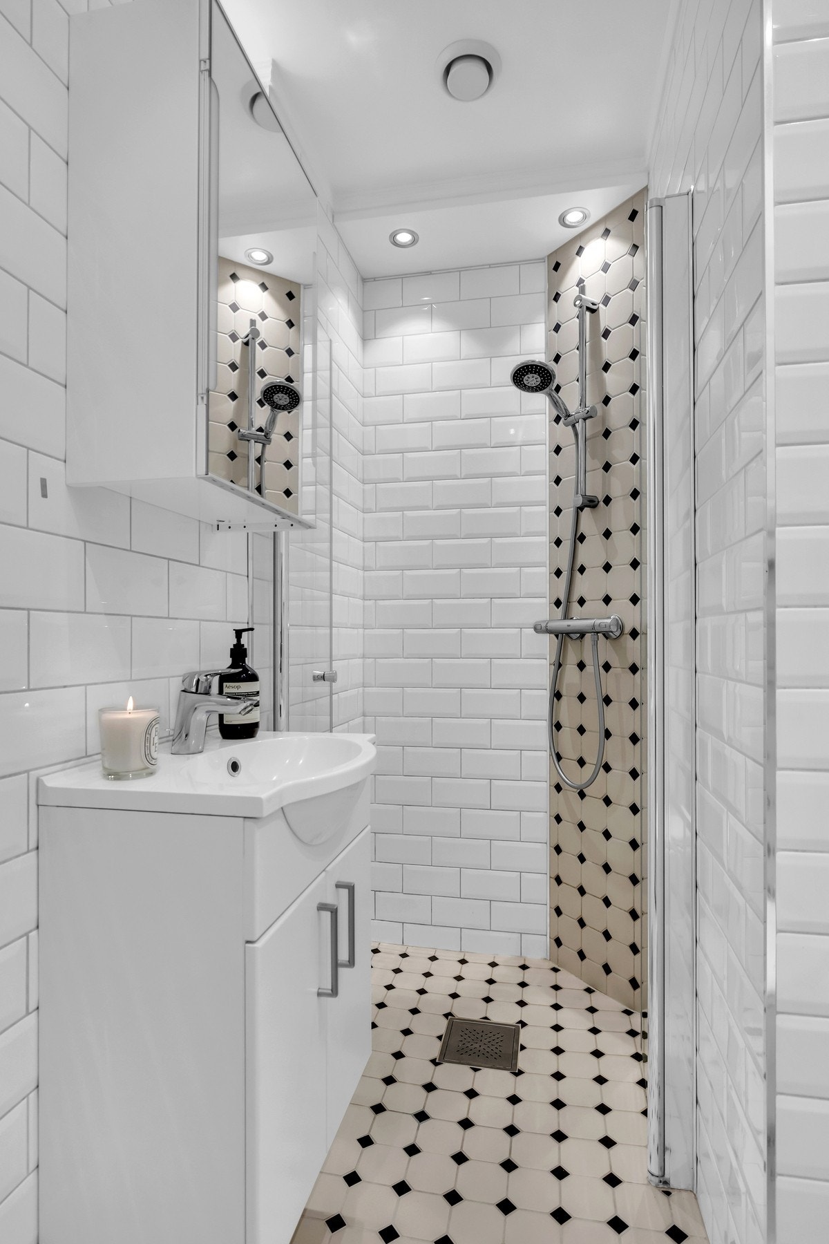 Badet er utstyrt med vegghengt toalett, dusjplass med glassvegger og servant i innredning. Galleribilde