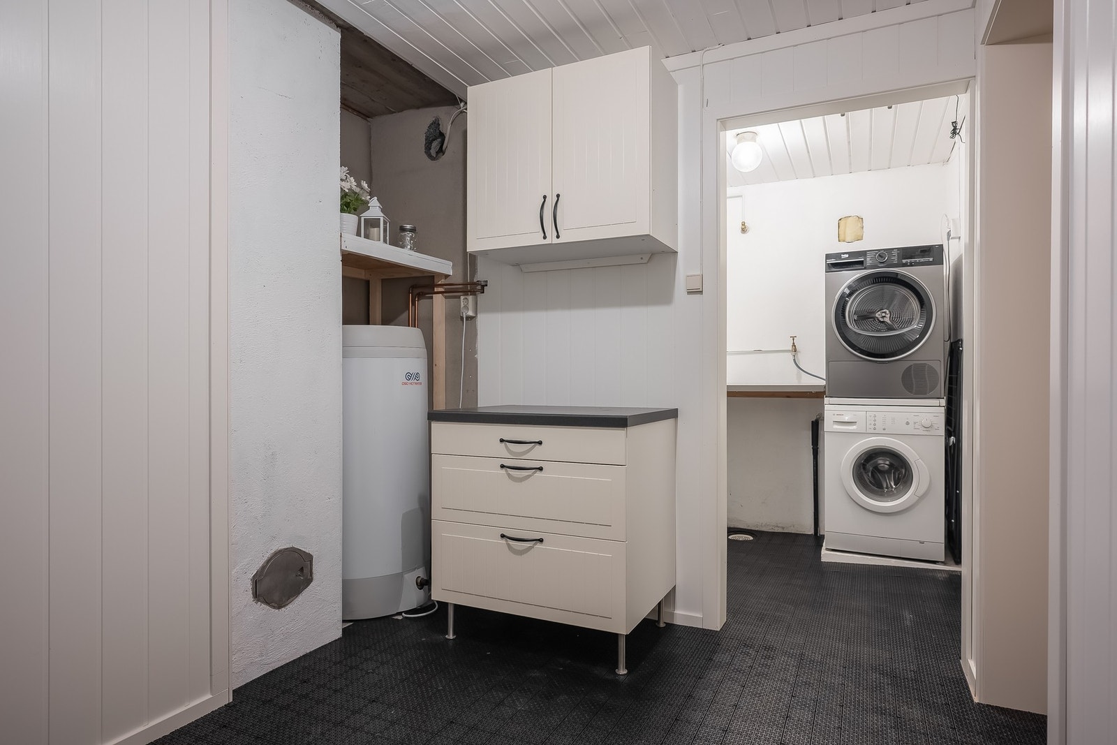 Praktisk vaskerom med utslagsvask på vegg og opplegg for vaskemaskin. Galleribilde