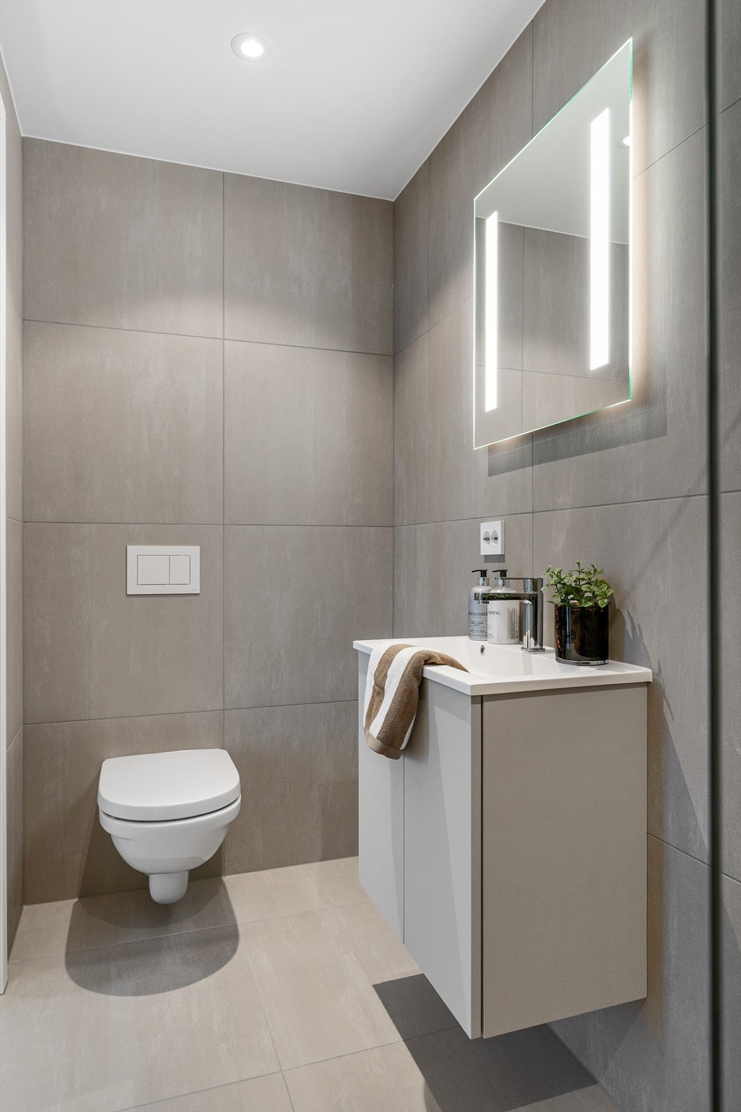 En-suite badet er innredet med toalett, dusjhjørne, servant med opplyst speil og downlights. Galleribilde