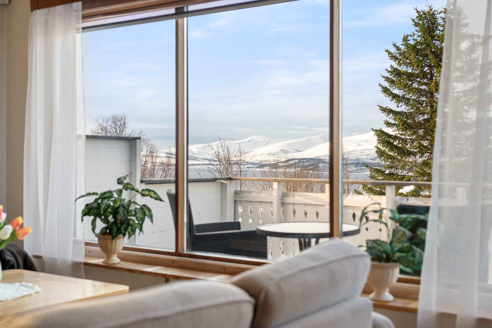 Stuen har store vindusflater i front som sikrer rikelig med innslipp av naturlig lys og fremhever utsikten.