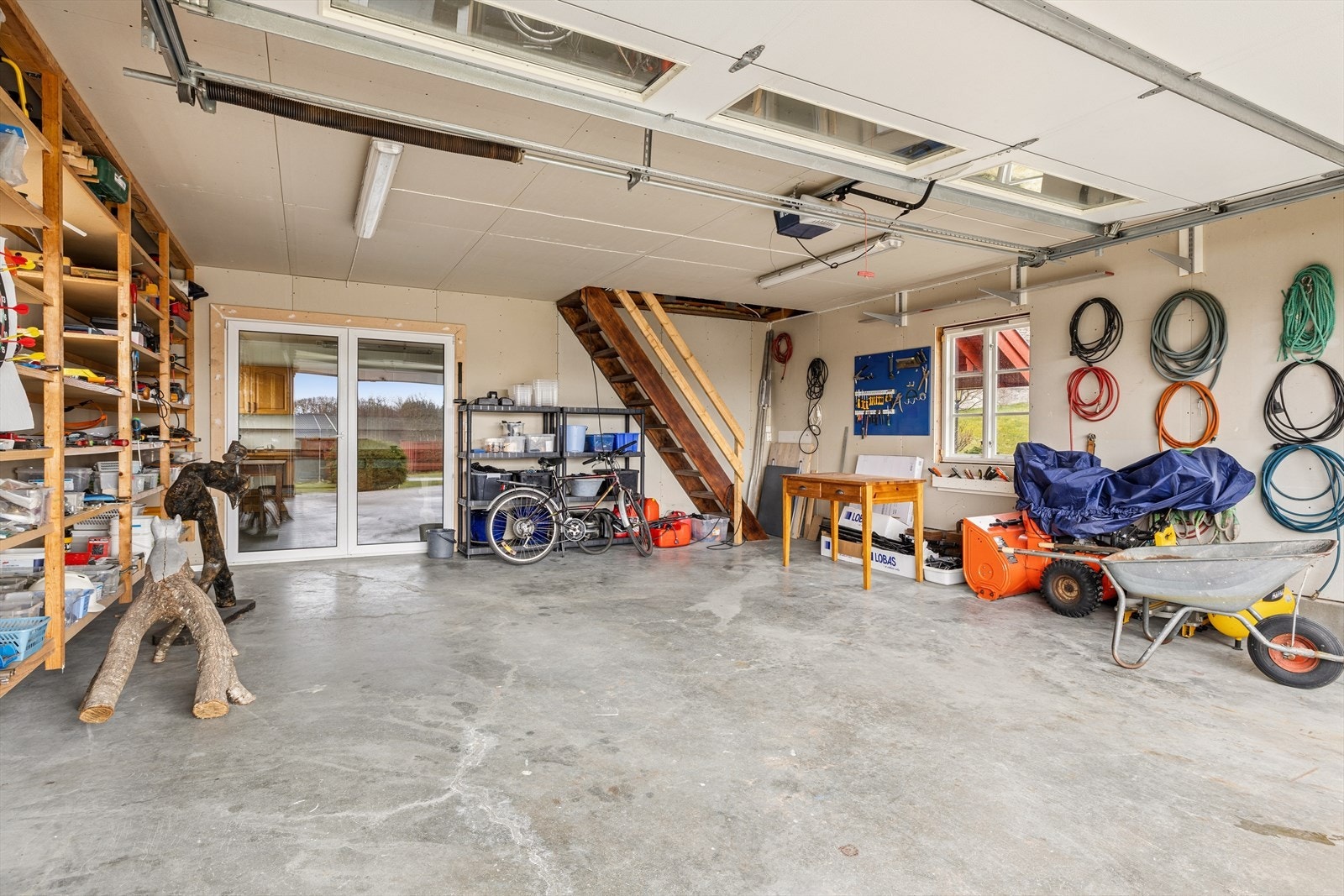Den romslige garasjen har god plass til både biler, utstyr og oppbevaring. Galleribilde