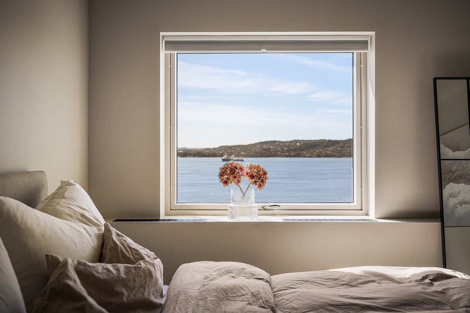 Elegant radiatorløsning integrert under vinduene, likt som i stuen, gir både effektiv oppvarming og et helhetlig uttrykk. Galleribilde