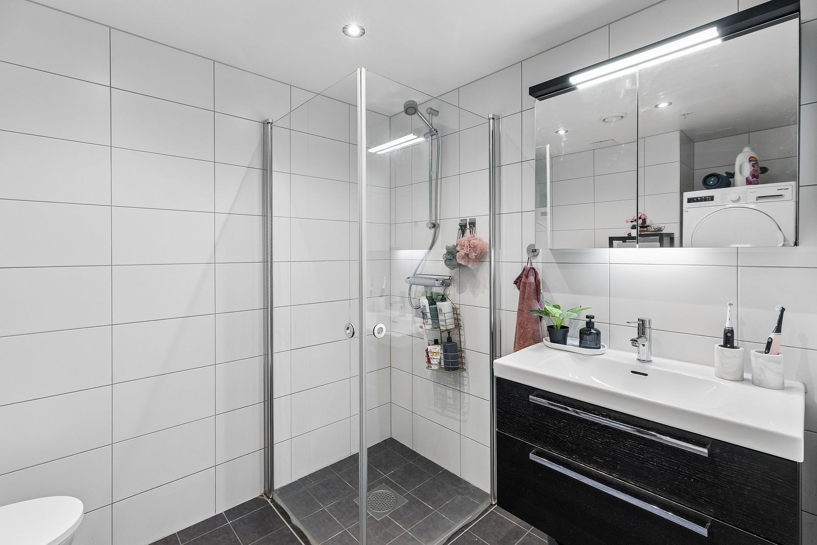 Pent flislagt bad innredet med både vaskemaskin og tørketrommel. Galleribilde