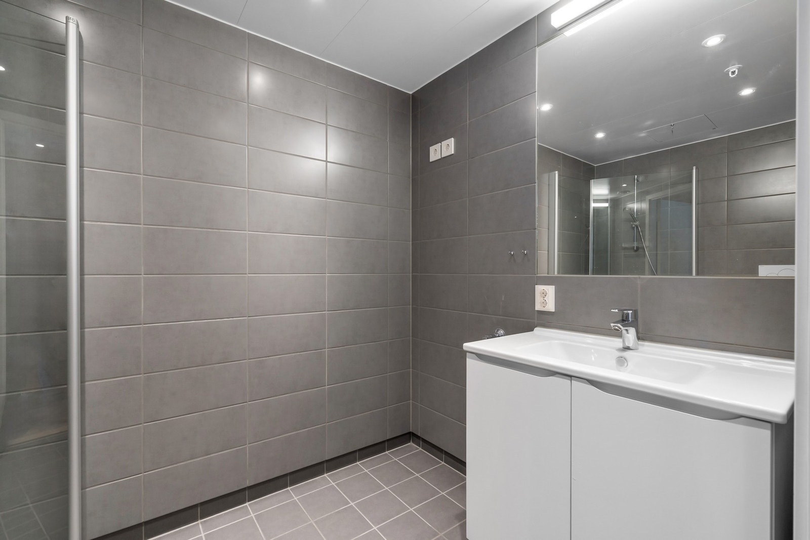 Pent, flislagt bad med downlights i himling, varmekabler i gulv og opplegg for vaskemaskin. Galleribilde