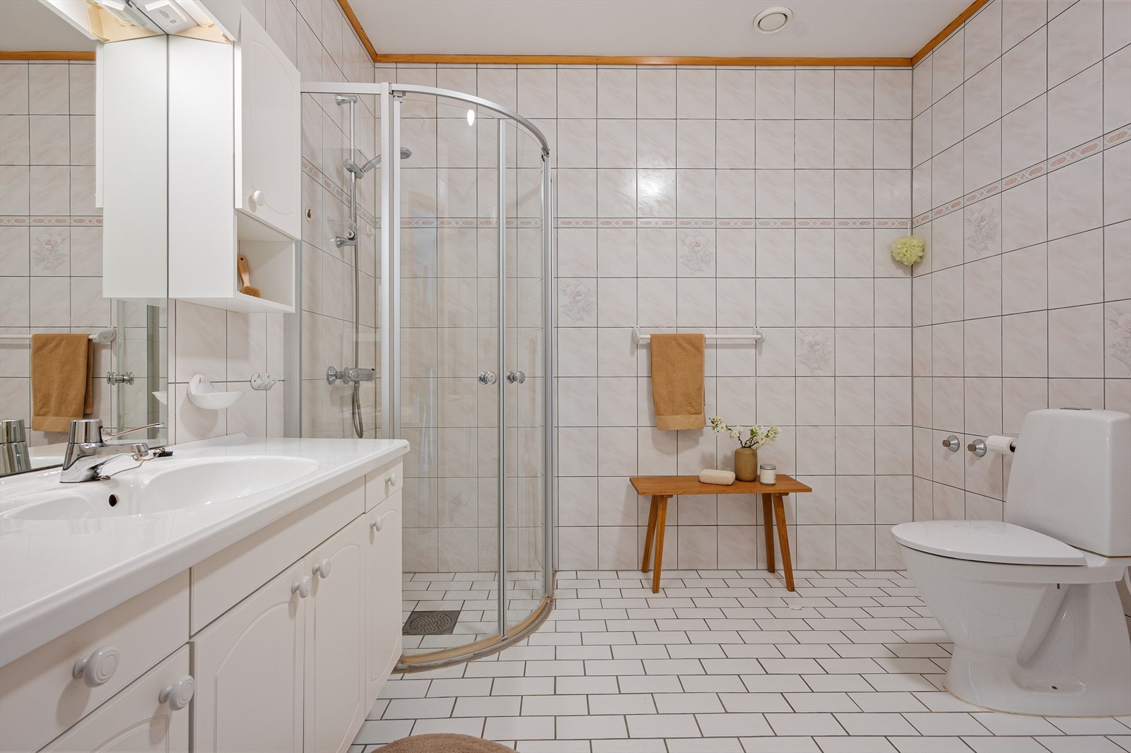 Badet er innredet med dusj m/dusjvegger, baderomsinnredning med servant, toalett, skap med utslagsvask, og opplegg for vaskemaskin og tørketrommel. Galleribilde
