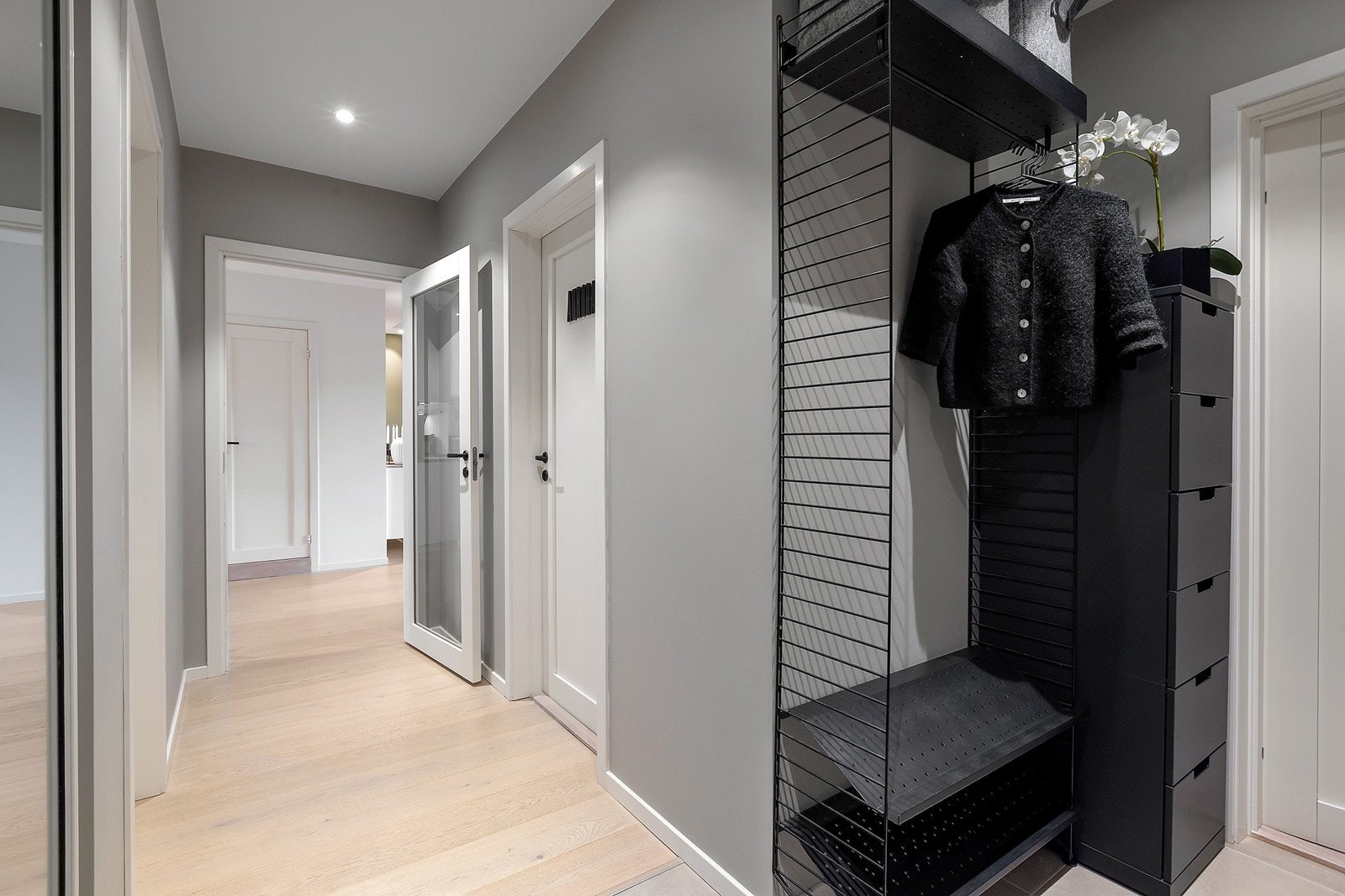 Romslig entre med pene gulv og downlights i himling. Plassbygd garderobeskap med skyvedører i front. Galleribilde