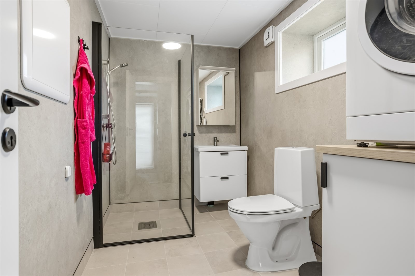 Badet i utleiedel har flislagt gulv med varmekabler, baderomsplater på veggene og opplegg for vaskemaskin. Galleribilde