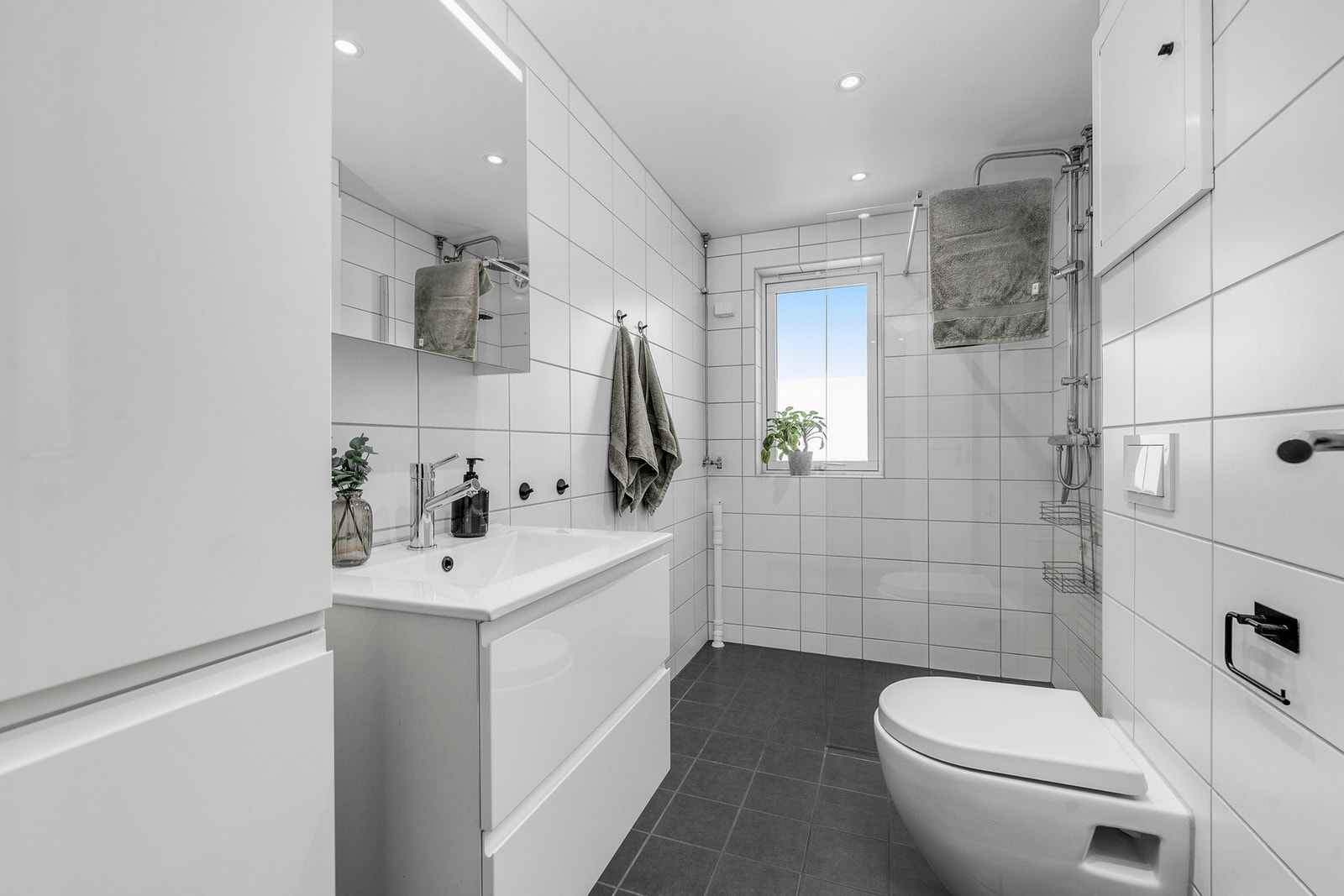 Flislagt bad pusset opp i 2020 med downlights i himling og vindu som gir naturlig lys og ventilasjon. Galleribilde