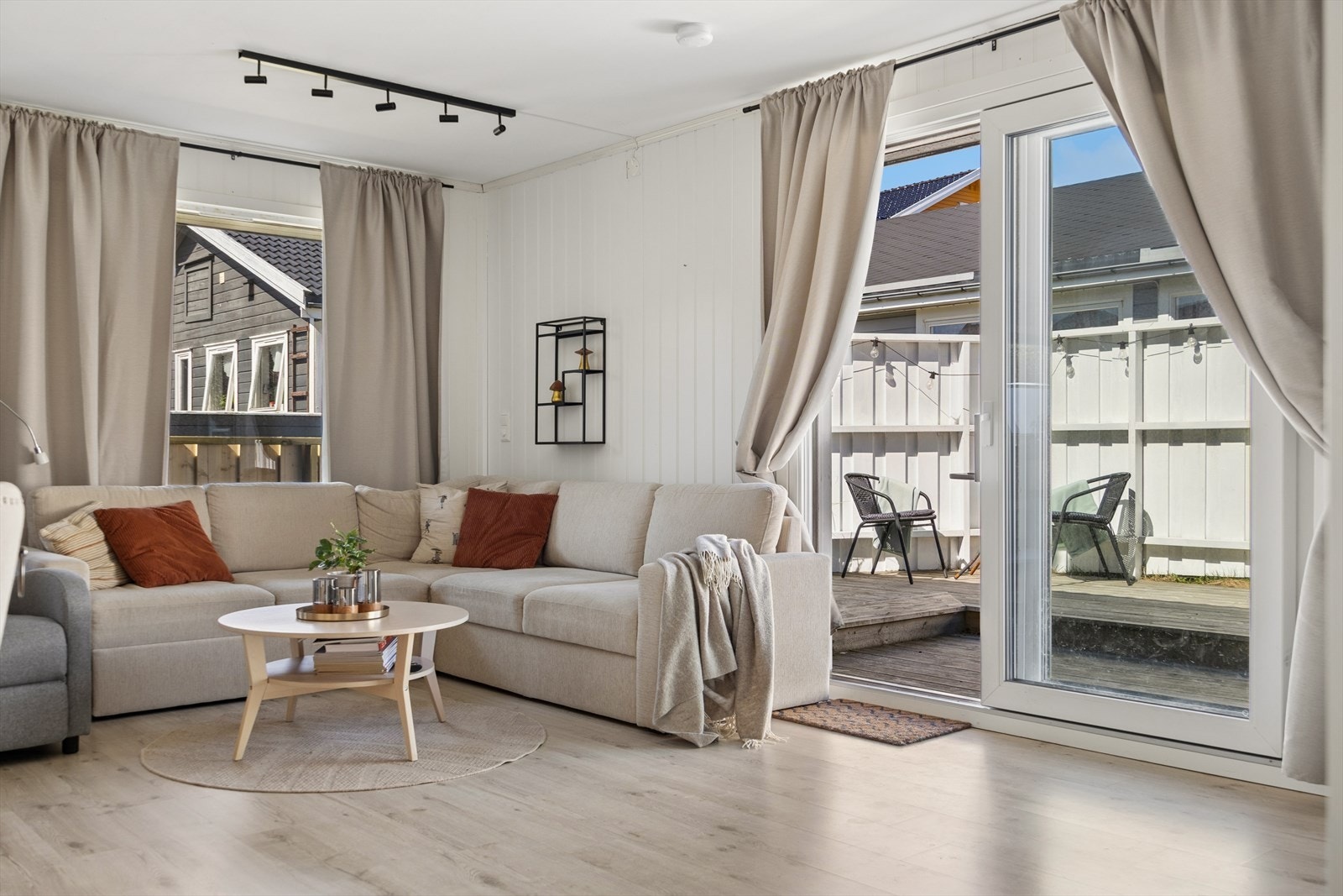 Stue med laminat på gulv og malt panel på vegger. Galleribilde