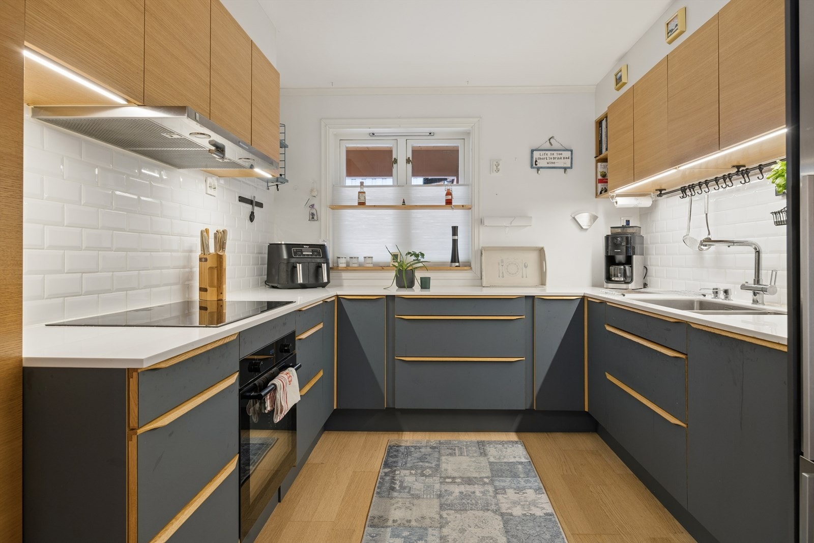 Integrerte hvitevarer er fra AEG og Miele. Benkeplaten er i lys Corian. Galleribilde