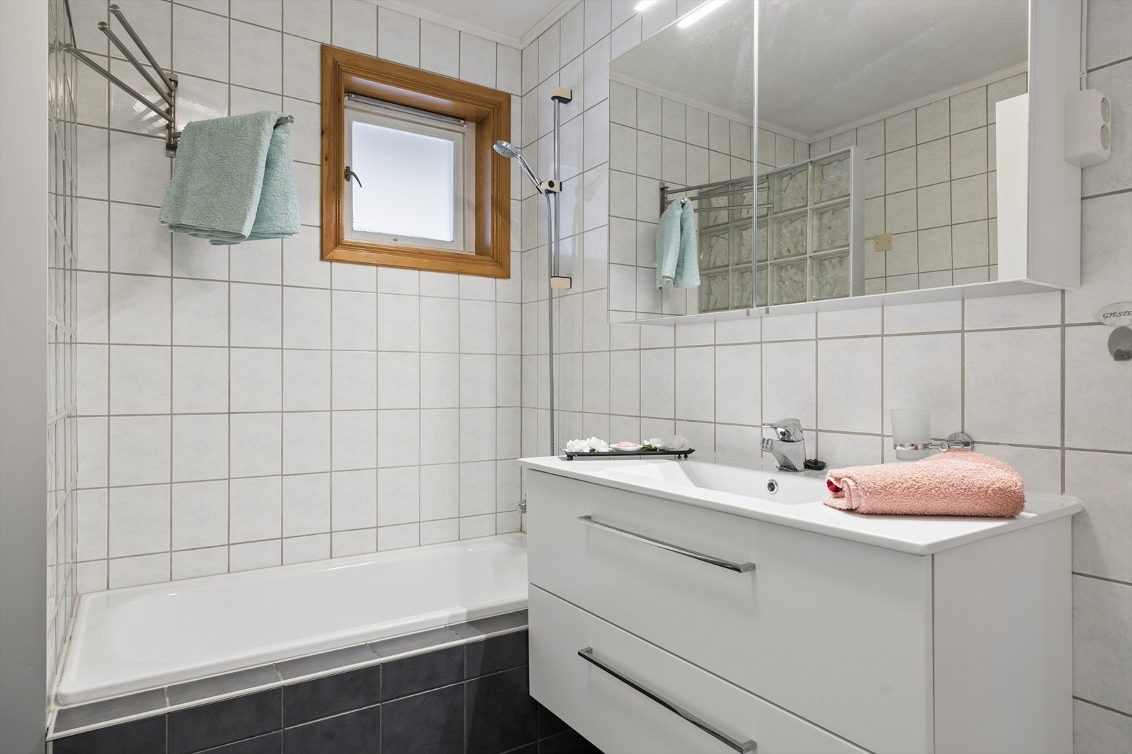 Funksjonelt bad med badekar, gulvmontert toalett og innredning med servant. Et praktisk rom tilpasset både hverdag og avslapning. Galleribilde