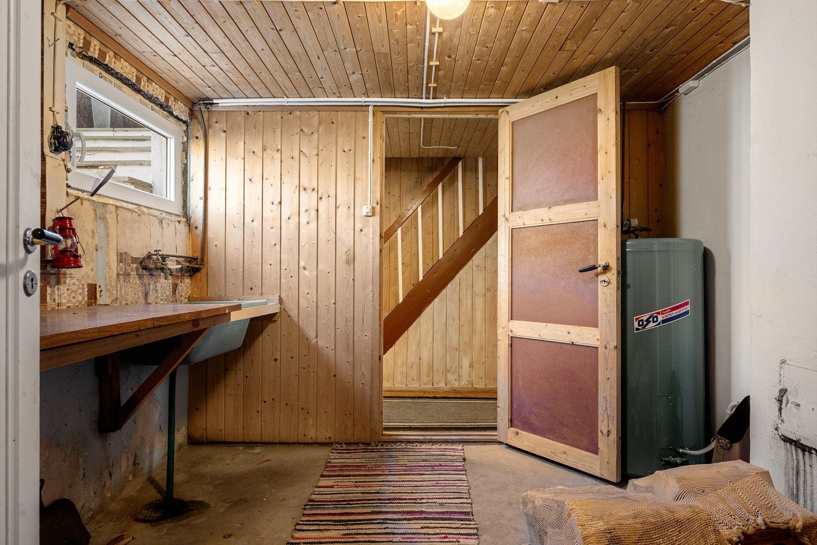 Praktisk vaskerom i kjelleren med utslagsvask og opplegg for vaskemaskin. Galleribilde