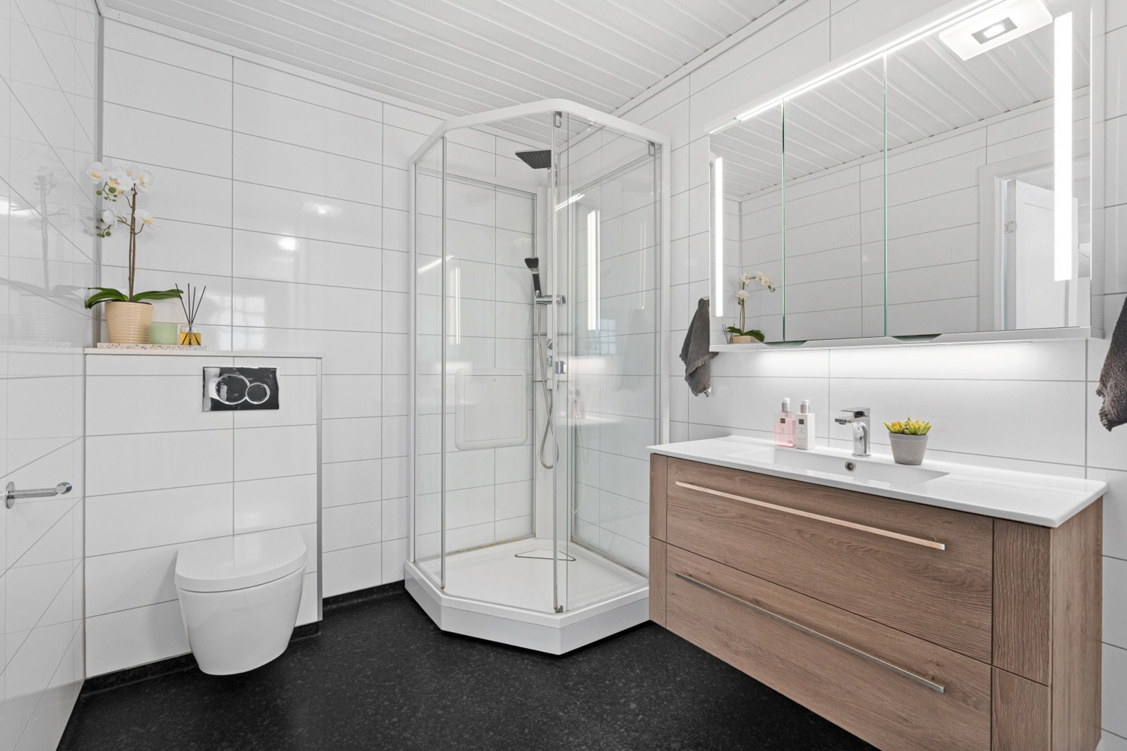 Boligen har to bad. Badet i hovedetasjen fremstår som stilrent og funksjonelt, med moderne standard. Rommet er innredet med romslig dusjløsning, vegghengt toalett og en praktisk baderomsinnredning med god oppbevaringsplass. Galleribilde