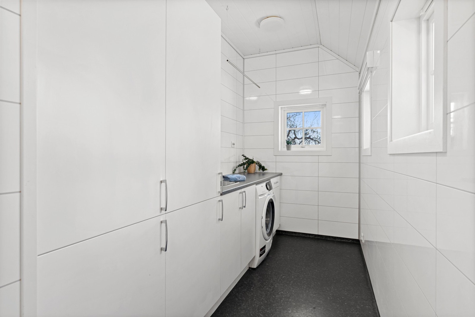 Boligen har et romslig og velorganisert vaskerom med gode løsninger for en effektiv hverdag. Her er det plass til både vaskemaskin og tørketrommel, samt rikelig med skapplass for oppbevaring.
Vaskerommet har i tillegg egen inngang. Galleribilde