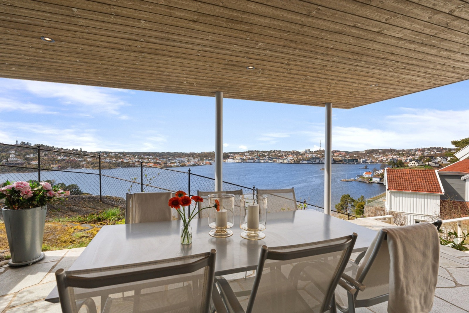Fra uteplassen kan du nyte en imponerende panoramautsikt over sjøen og nærområdet. Den overbygde løsningen gir ly for vær og vind, samtidig som du sitter tett på naturen og utsikten. Galleribilde