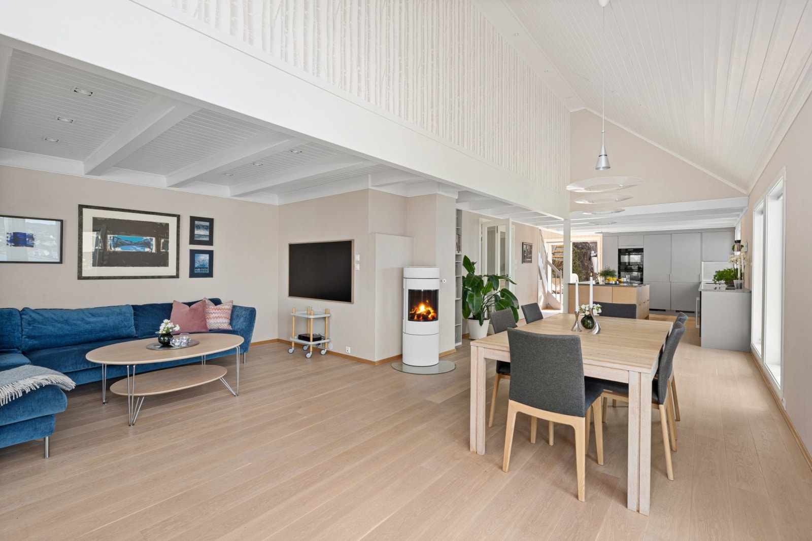 Planløsningen gjør det enkelt å møblere i ulike soner, med en naturlig inndeling mellom sofagruppe og spiseplass - perfekt tilpasset både hverdagsliv og gjestebesøk. Galleribilde