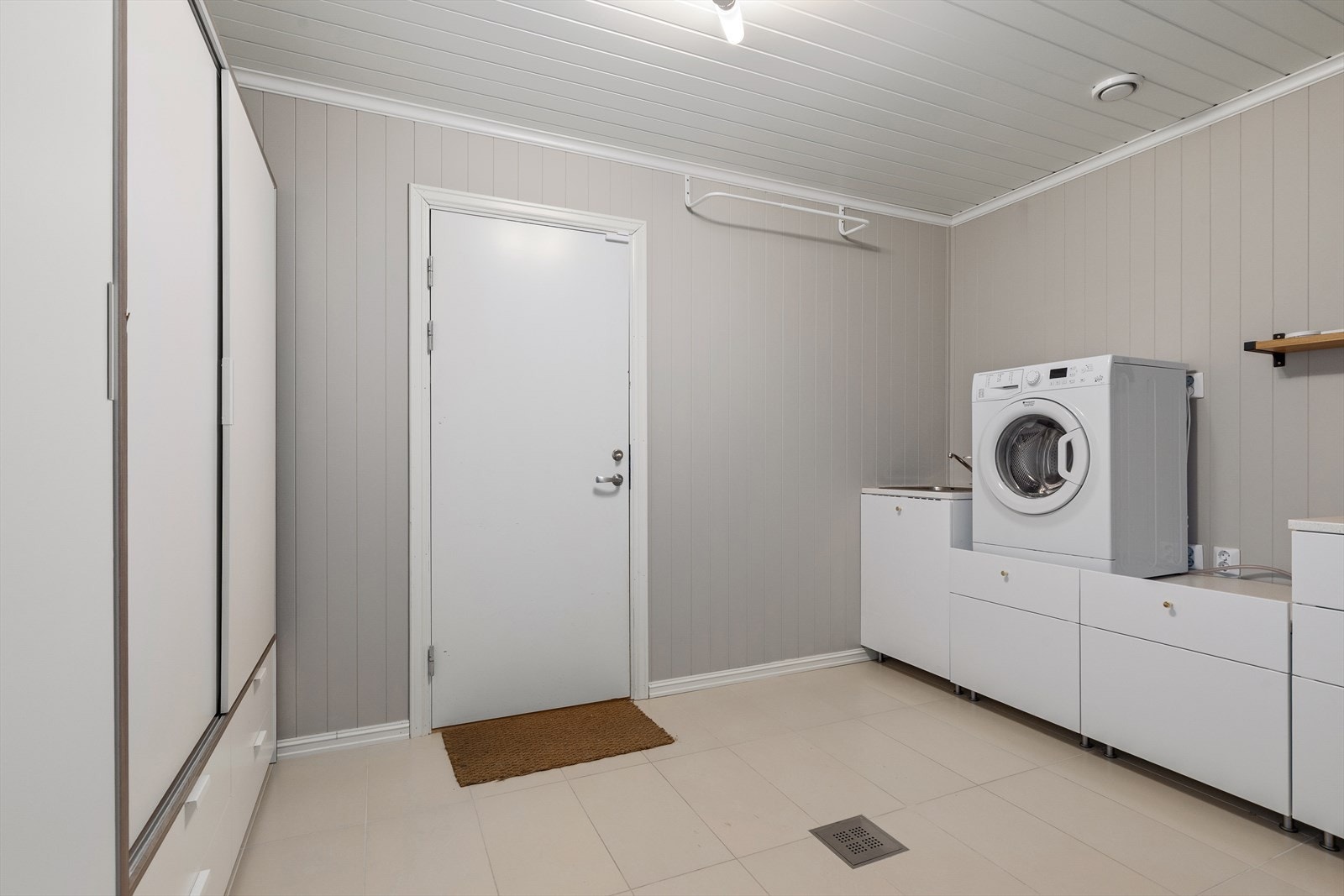 Vaskerommet i underetasjen er romslig med praktiske løsninger som inkluderer vaskekum, benkeplate, skyvedørsgarderobe og opplegg for vaskemaskin. Galleribilde
