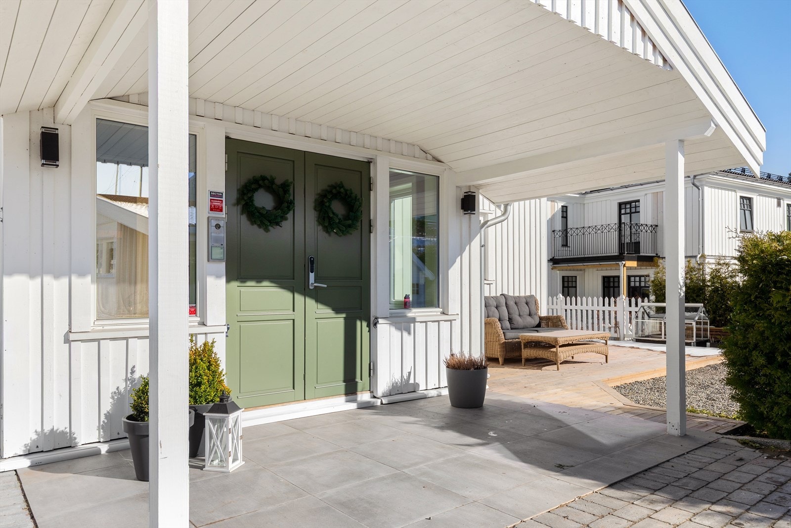 Boligen har adkomst via en overbygd platting, som gir en lun og hyggelig velkomst. Inngangspartiet er opparbeidet med fliser og belegningsstein, og har plass til en sittegruppe. Galleribilde