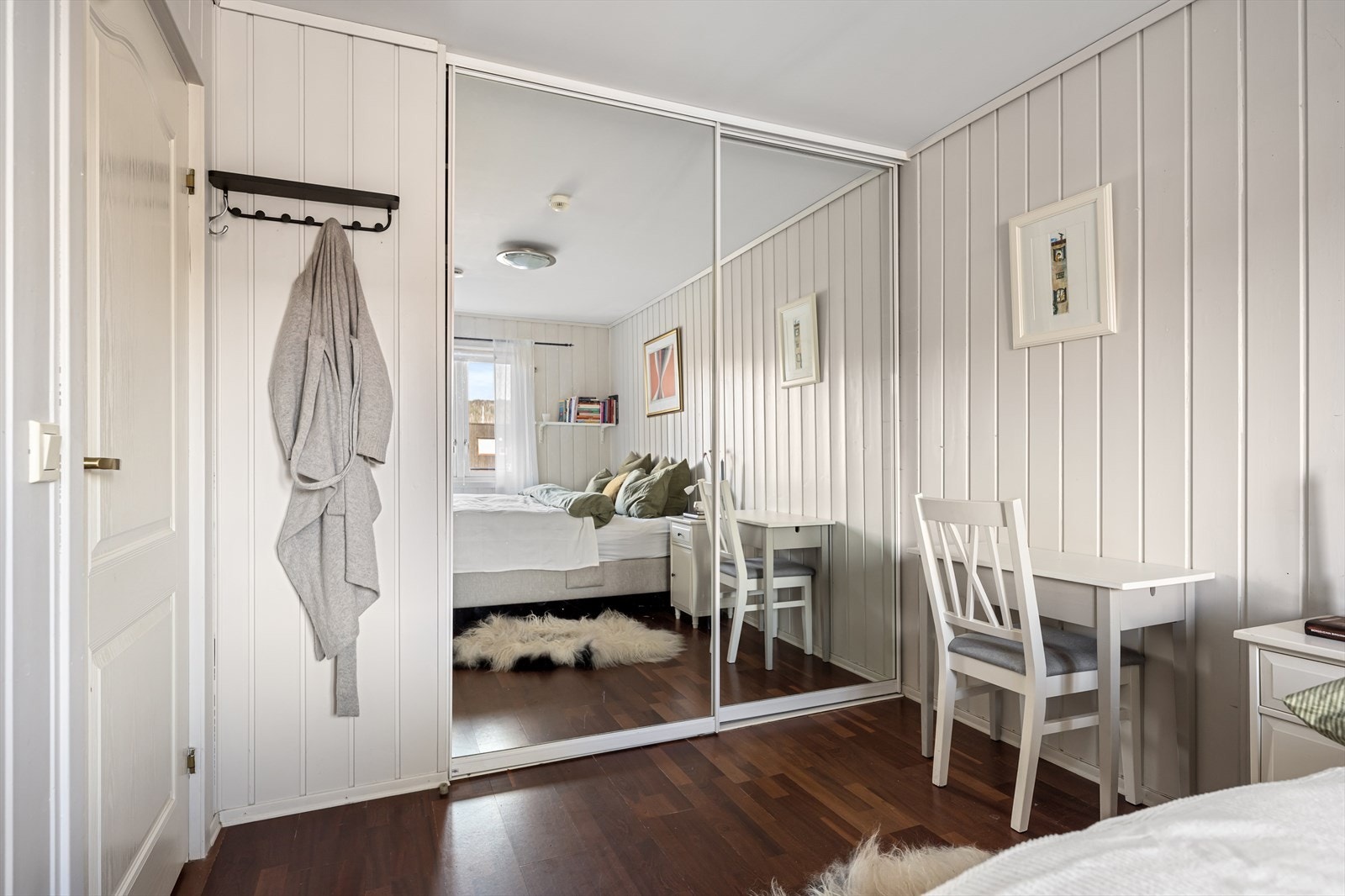 En romslig skyvedørsgarderobe med speilfronter gir rikelig med oppbevaringsplass. Galleribilde